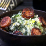 sausages and vegetables cooked in a bowl